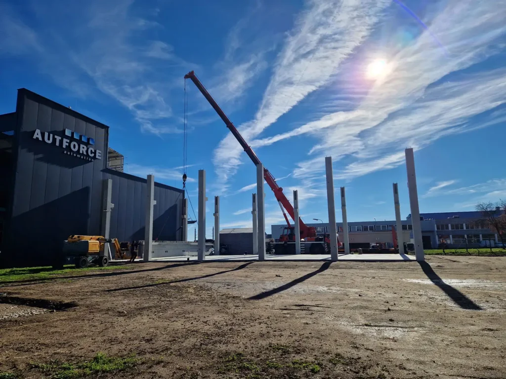 Kranarbeiten und erste Pfeiler für Wände und Dach beim Zubau des AUTFORCE Headquarters in Lebring