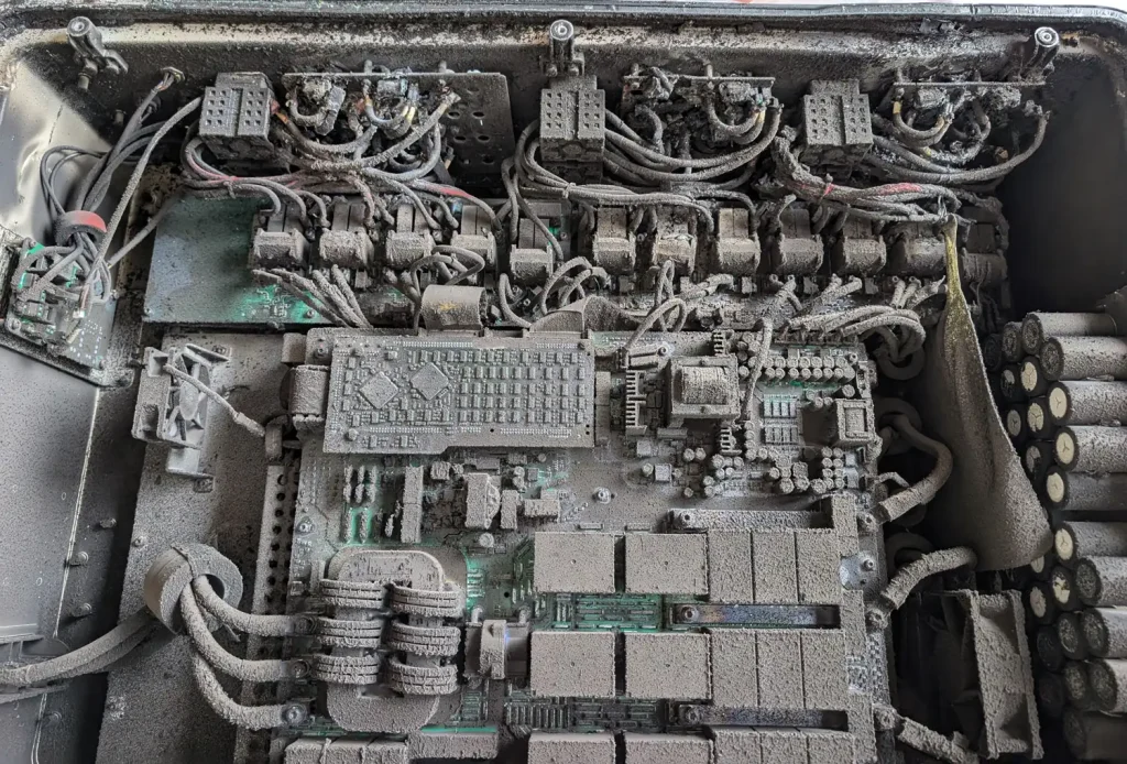 Analyse eines defekten PV-Wechselrichters mit Brandschaden – Testing-as-a-Service. Defekter PV-Wechselrichter mit sichtbarem Brandschaden während einer Analyse bei der die Brandursache ermittelt wurde.