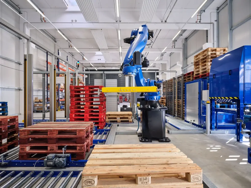 In der Palettensortiermaschine PalletSort Max von AUTFORCE entnimmt ein Roboter die geprüften Paletten aus der Palettenkontrolle und legt sie dann auf vordefinierten Ausgabebahnen ab, wo sortenreine Palettenstapel gebildet werden. 