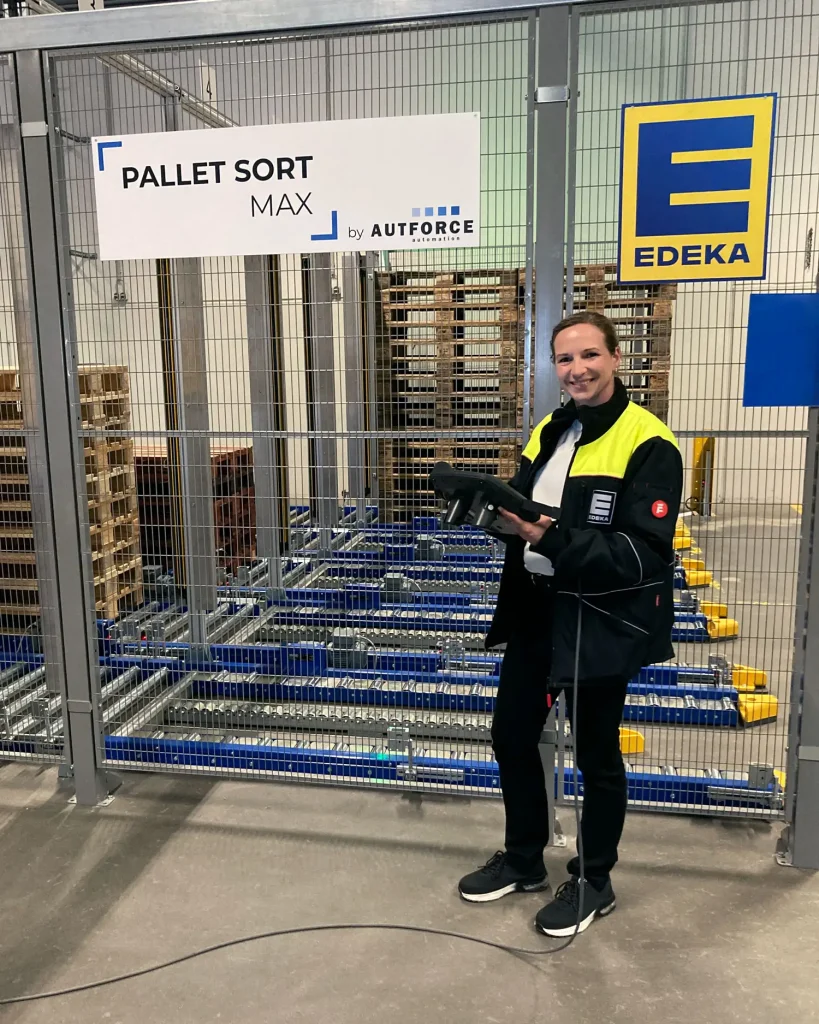 Projektmanagerin von EDEKA vor der PalletSort Max Palettensortieranlage von AUTFORCE